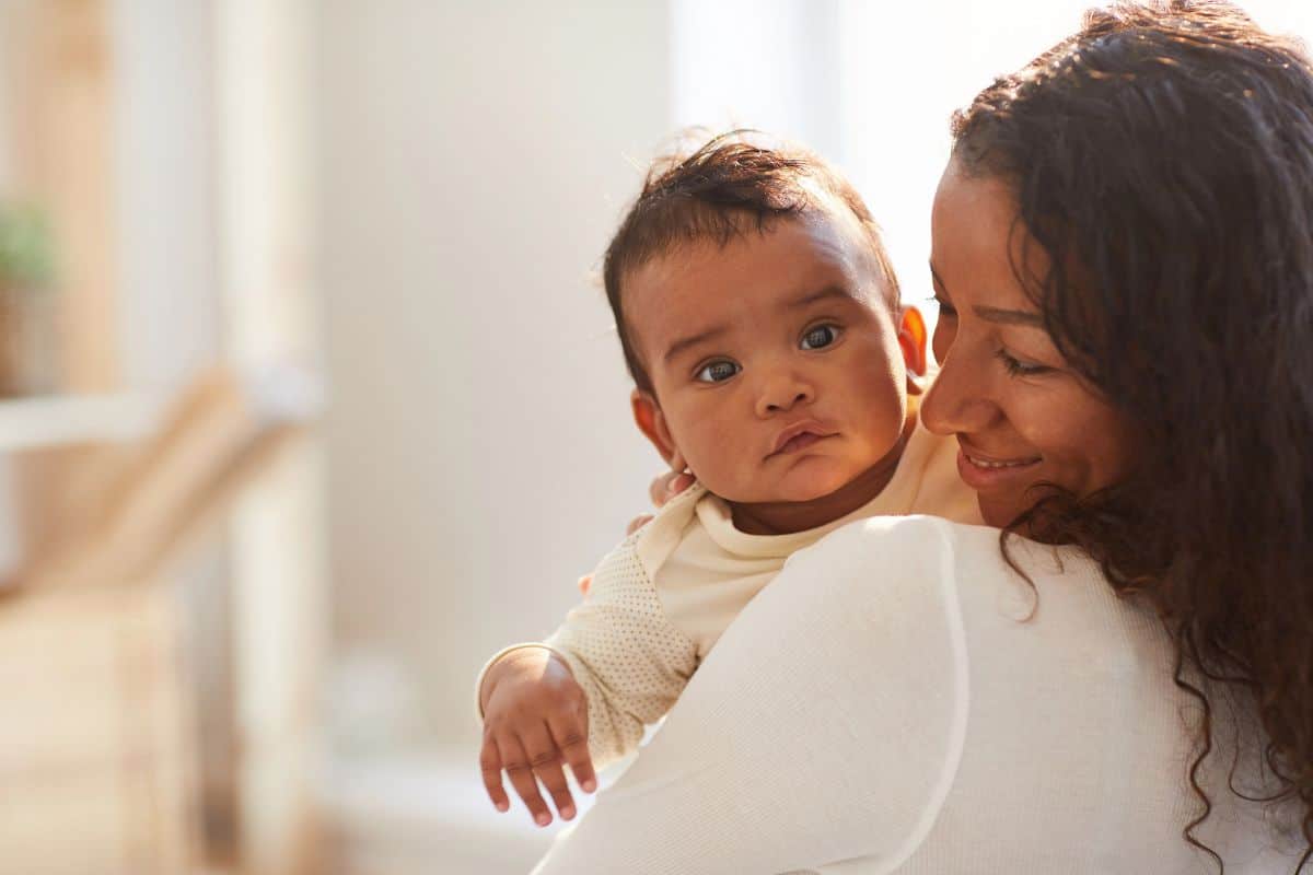 African american mom holding her baby against her shoulder