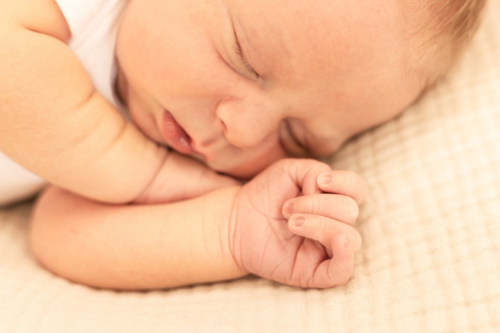 Baby asleep curled on his side