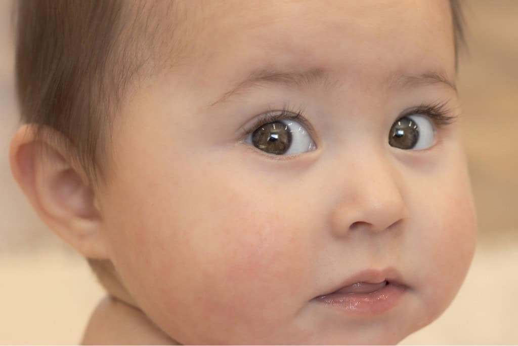 baby girl with big brown eyes looking into camera